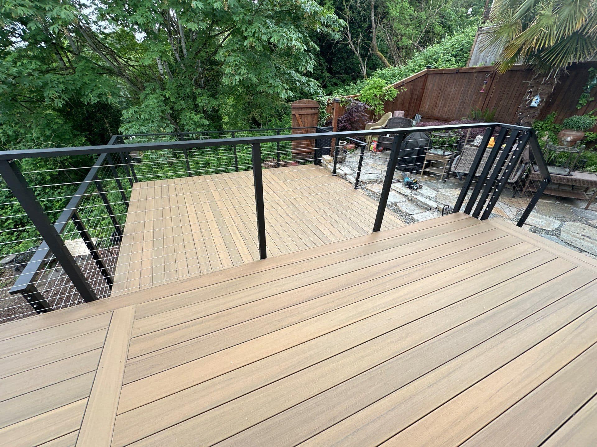 Tan composite deck with stainless cable railing system, custom-built by Ascend General Contractors in Bellevue